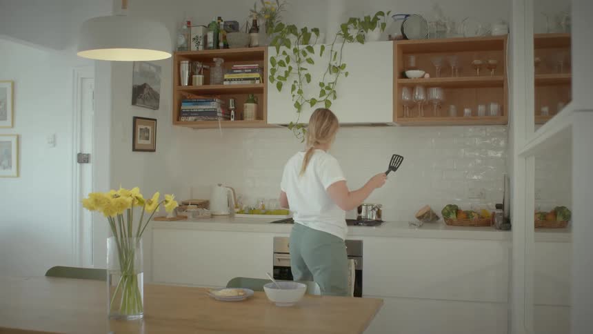 A lady preparing meal in the kitchen at home