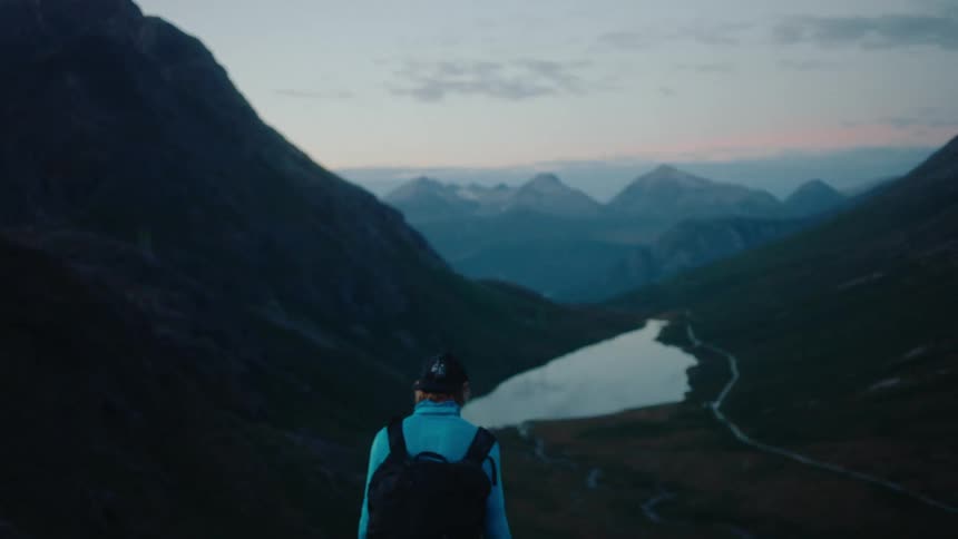 A man is hiking towards some mountains