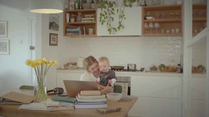 A mother and son talk on the laptop