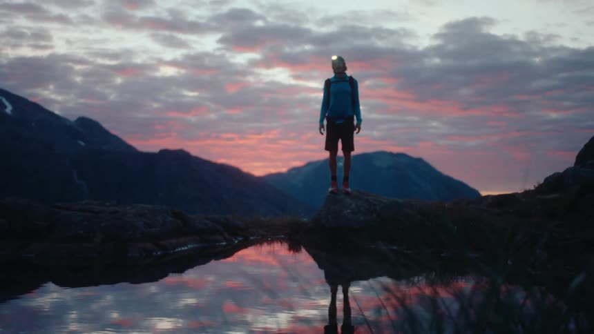 A man walks around the mountain lake