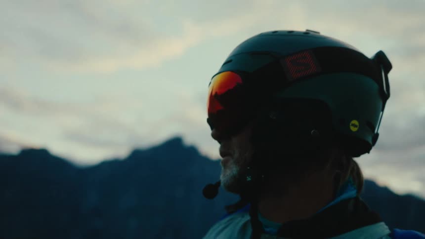 A man wearing a special cap and observing the view in a natural environment at dawn