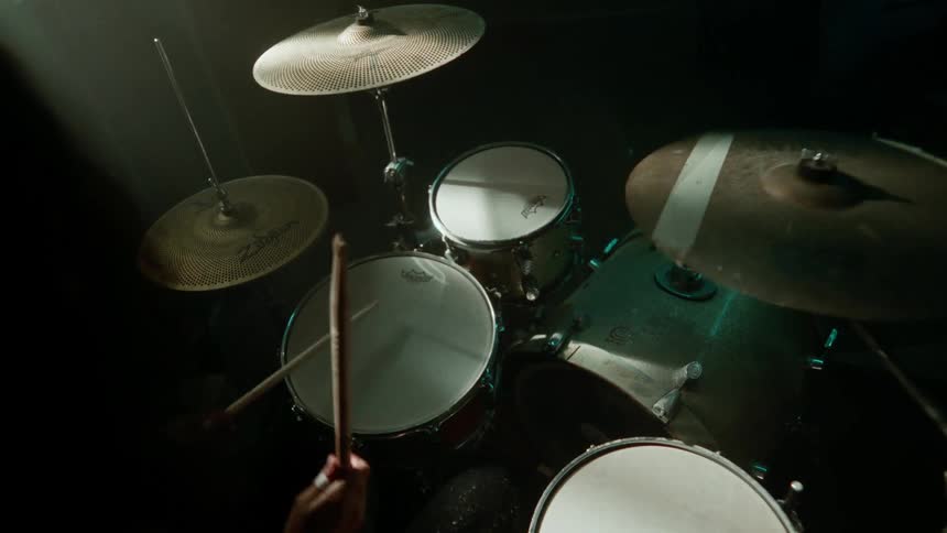 A persons hand playing the drums