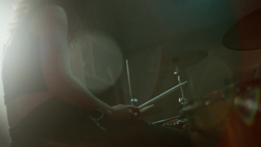 Female drummer playing her instrument indoors