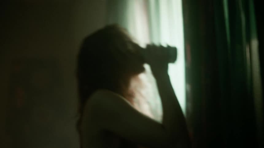 A woman with wet hair inside a house having a drink