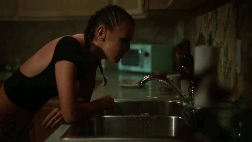 An angry woman leaning on the kitchen sink