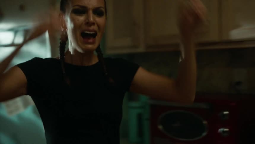 Young woman in distress screams in the kitchen at home