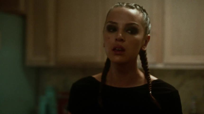 Young woman walking in the kitchen crying and sad