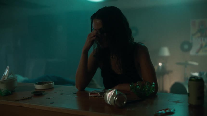 Upset woman paces back and forth in smoky room then leans against bar counter