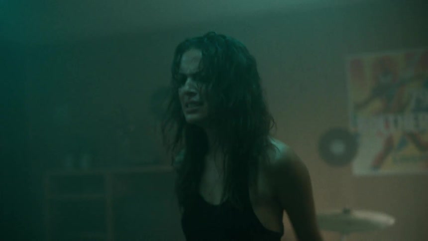 A girl screaming angrily in a dark room