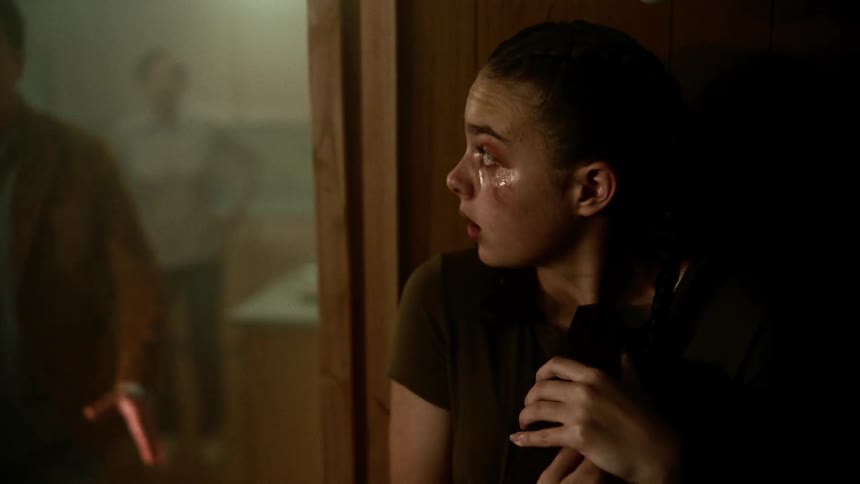A teenage girl with a bruised face is nervous and sad as she listens to people arguing behind her