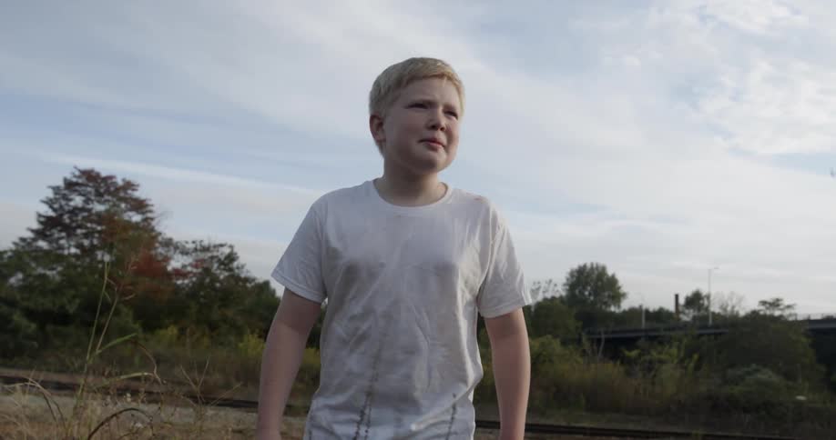 A boy is hiking outside on a cloudy day