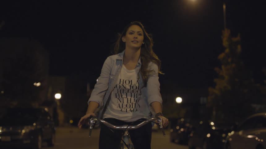 A woman is riding a bicycle at night