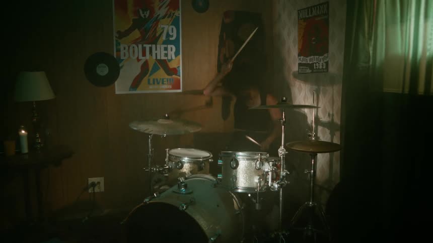 A woman playing the drums with strength and energy