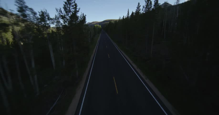 A road through a forest in a mountainous countryside during the day