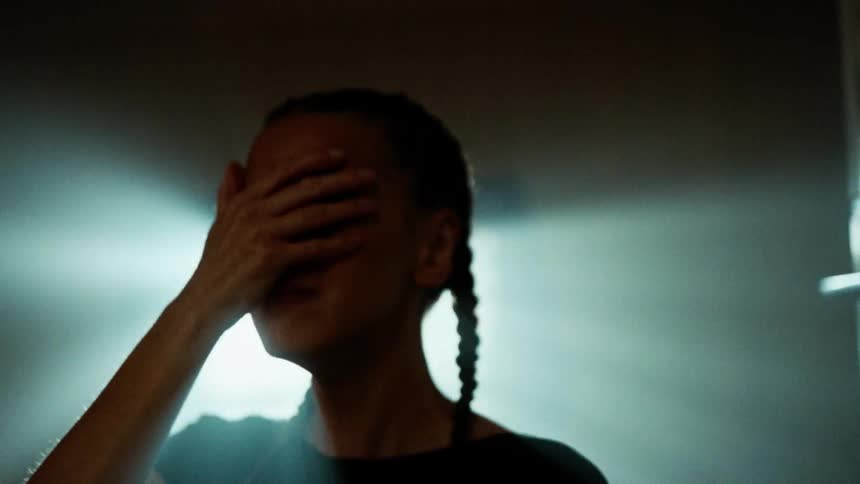 A woman with her hands on her head screaming in frustration and sadness at the same time