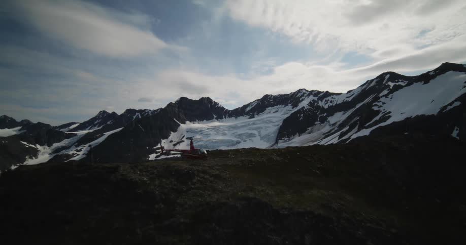 A red helicopter on top of a mountain
