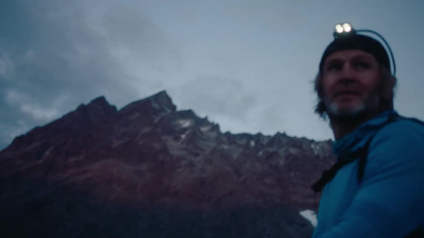 Hiker looks at a mountain range in the morning