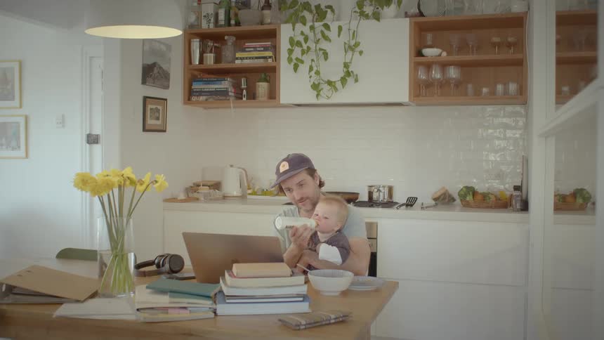 A father is feeding his son with a bottle