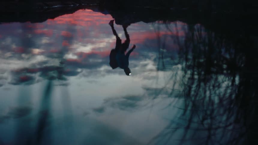 Reflection of a person in the lake water at dusk