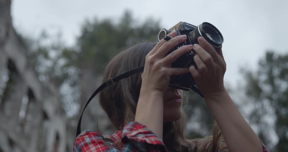 A woman takes a photograph and walks off