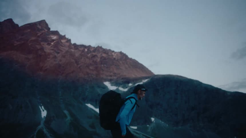 Man carrying a backpack hiking in the mountains at morning