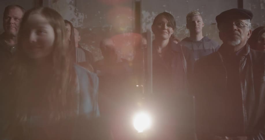 A group of people watch a film reel