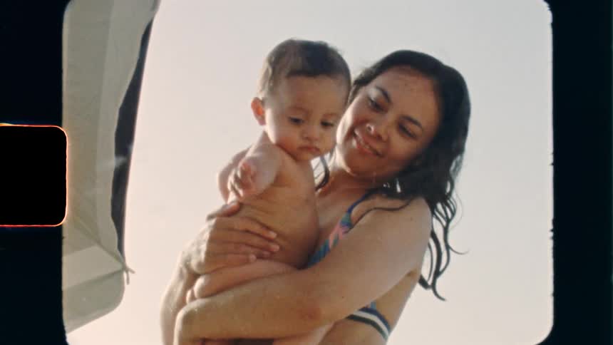 Super 8 film of a mother holding her child at the beach