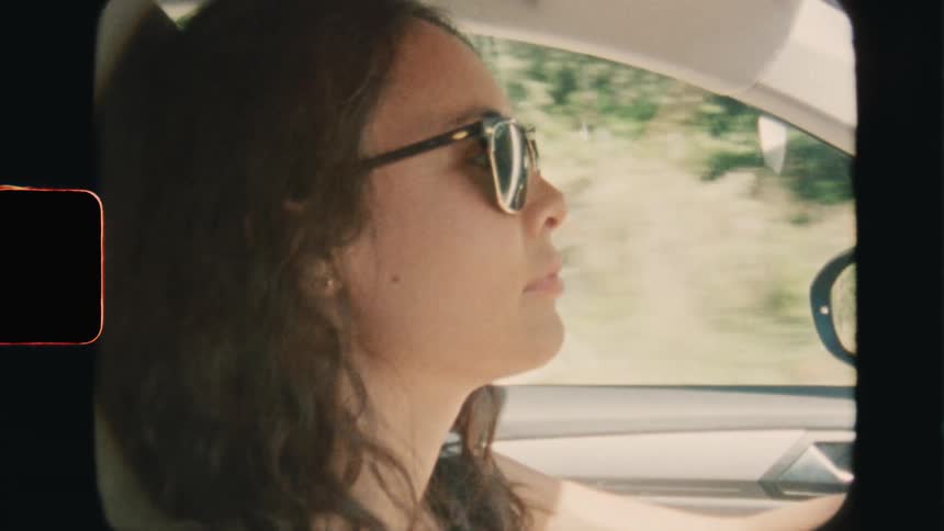 Super 8 film of a woman is driving her car on vacation