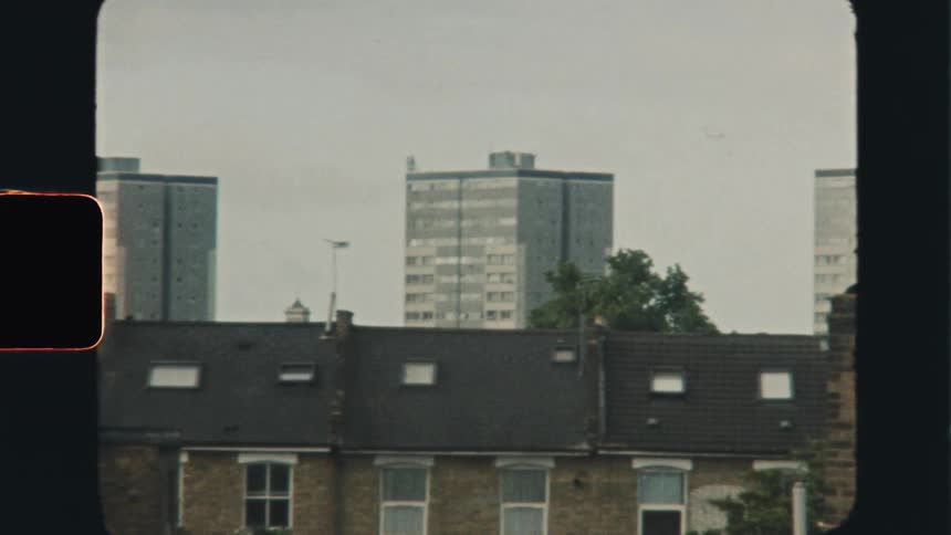Super 8 film of an urban city area with a distant flying plane