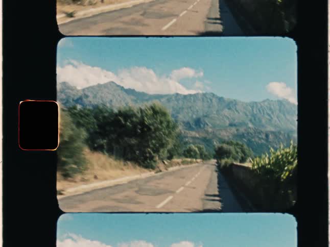 Super 8 film of a road which leads to a large mountain, overscan