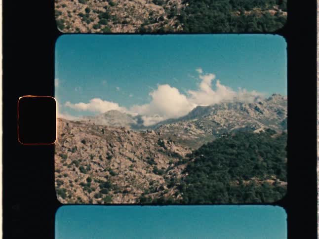 Super 8 film of clouds and mountains, the camera zooms in