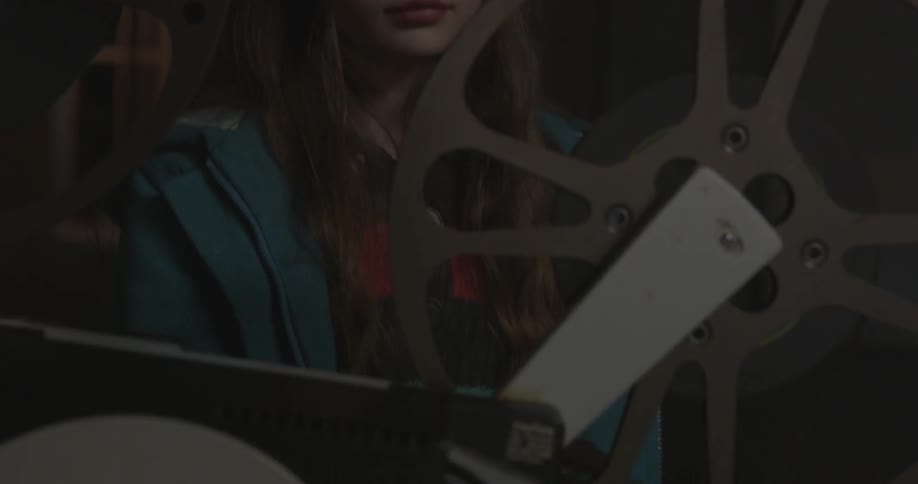 A girl walks over and examines a projector