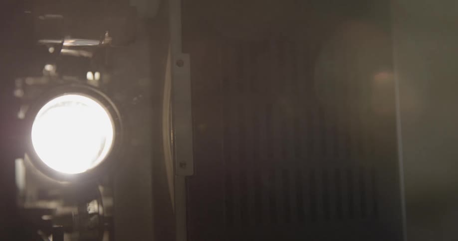 A projector light is running in a dark room