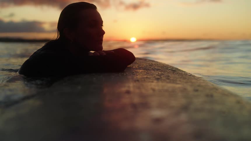 A woman swimming and meditating by the seashore