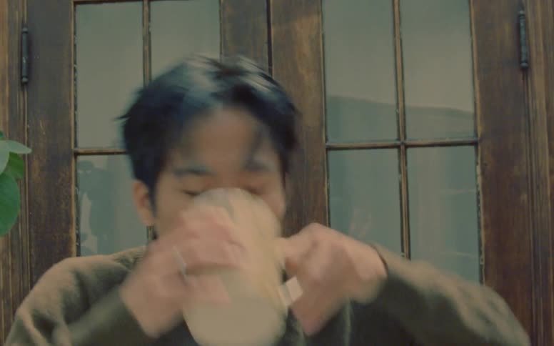Male dancer mimes taking a drink before turning his head