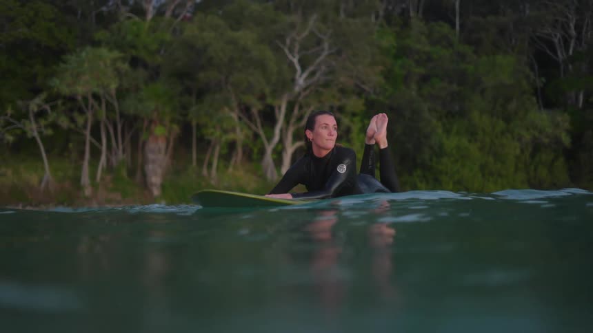 A woman out at sea on her surfboard