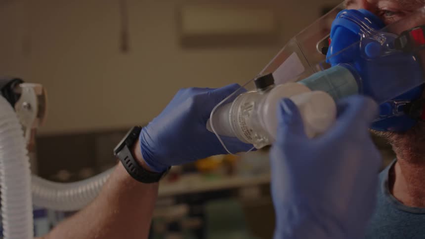 A tube mask is being fixed on an elderly man