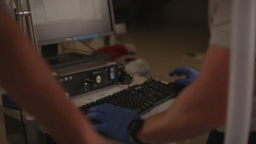 Hand in a glove operating and typing on a computer in a medical office