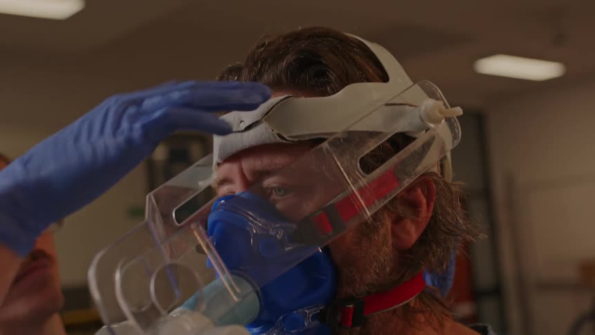 A doctor wearing an oxygen mask and protective helmet