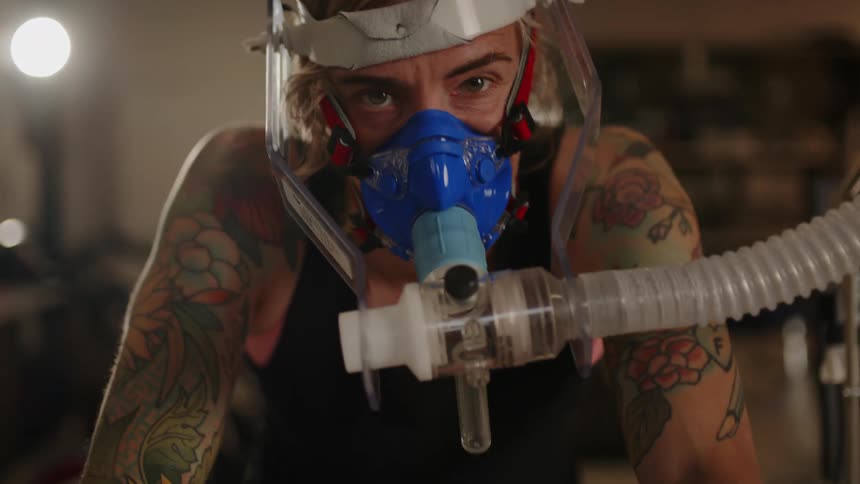 Man wearing vo2 mask pedals on stationary bicycle during fitness test