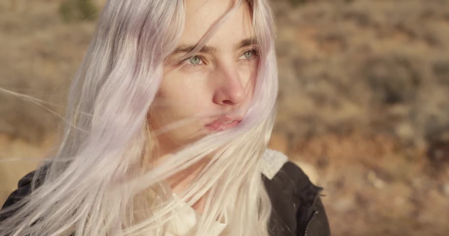 Blonde woman enjoying  the country air as it softly blows her hair