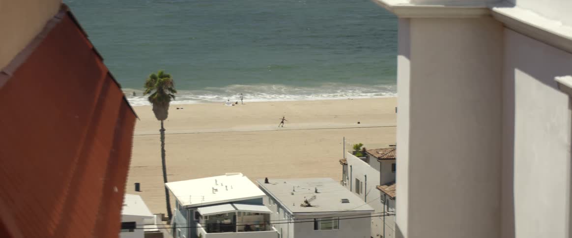 Someone dancing with only shorts on at the beach on a sunny day