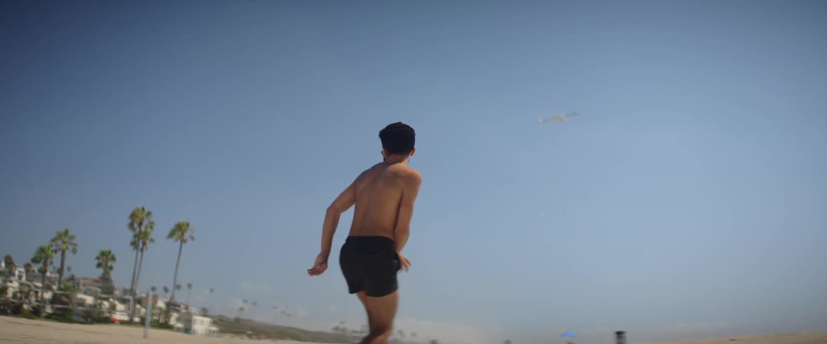 A man dancing on roller skates at the beach