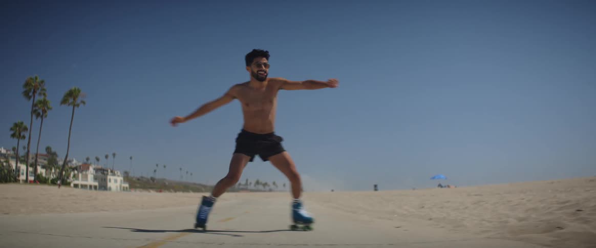 Man skates along road between apartments and beach