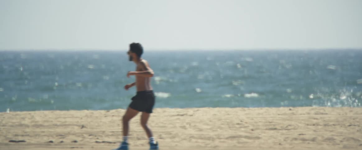 Man in shorts roller skates near the beach