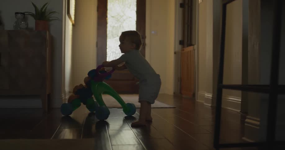 A toddler playing with a baby car