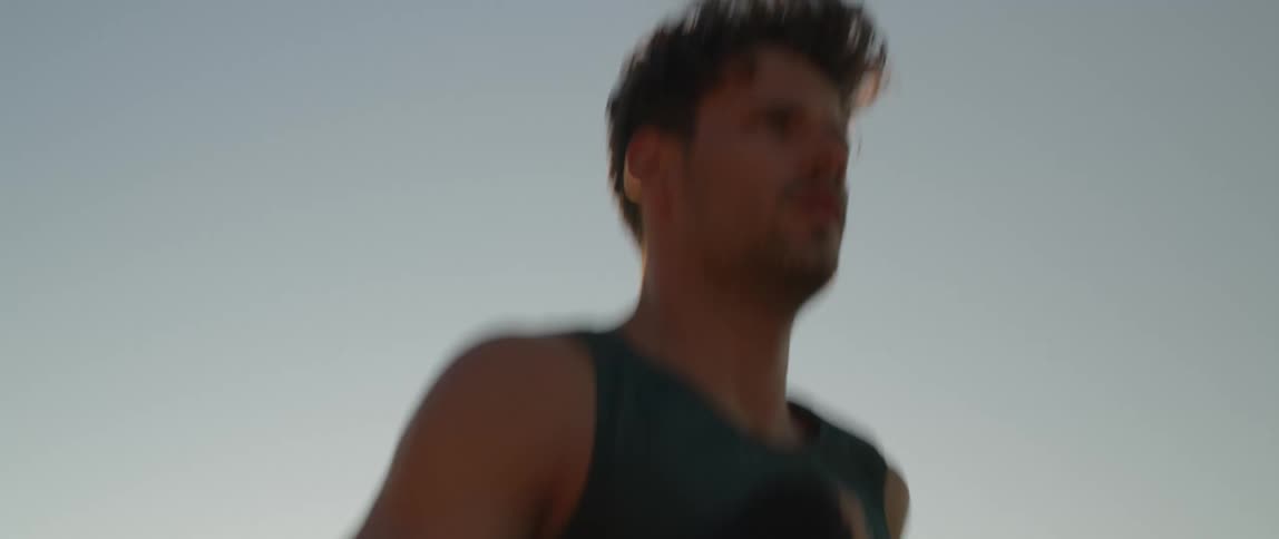 A man running on the sidewalk at the beach at dawn