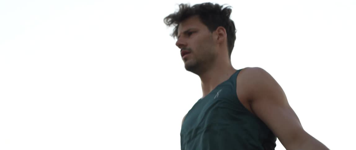 An athletic man wearing tennis shoes exercises by jumping rope