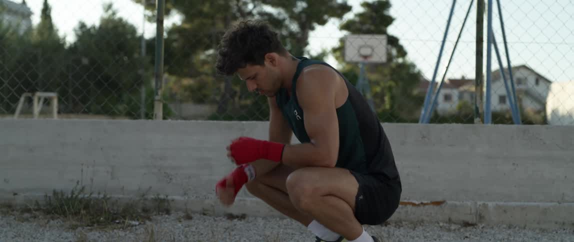 A tired man stopped jogging to rest at sunset
