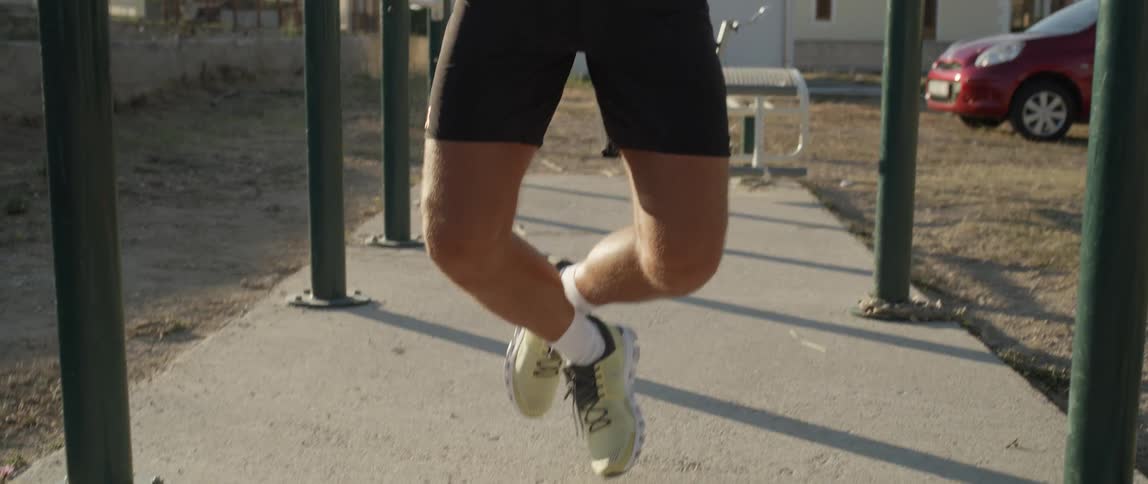 Closeup on the legs of a man doing pullups